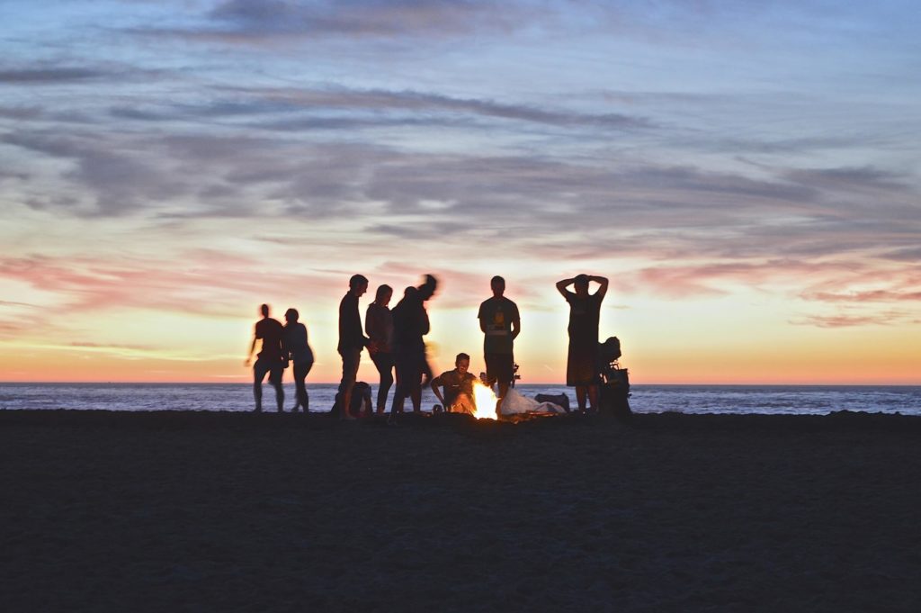 kimson-doan-people around fire on the beach at sunset